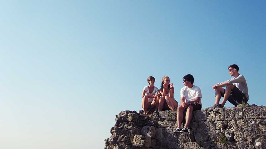 Junge Leute sitzen auf einem Fels